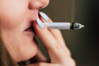 kadın elinde ortak. Bir kadın esrar ot çekiyor bir. Siyah bir arka plan üzerinde duman. Tıbbi esrar kullanım ve yasallaştırma esrar kavramları.