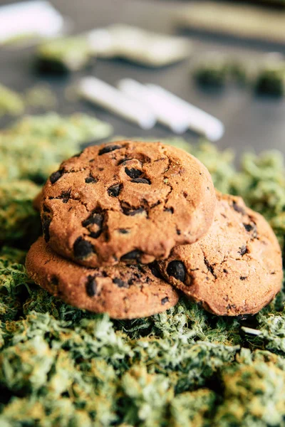 Biscoitos com maconha e botões de maconha na mesa. Conceito de cozinhar com erva de cannabis. Tratamento de maconha medicinal para uso em alimentos, em um fundo preto — Fotografia de Stock