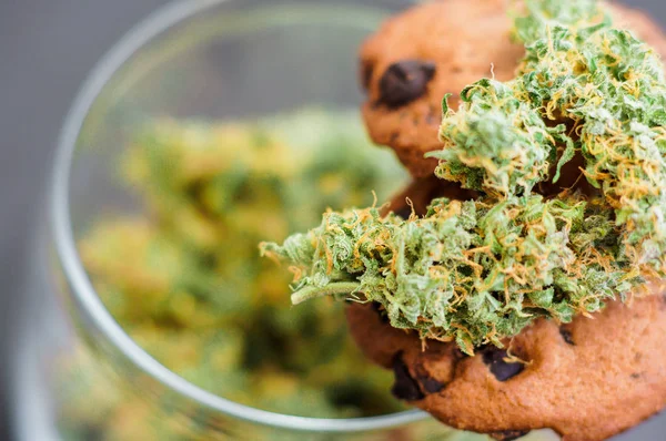 Cookies med cannabis och marijuana-knoppar på bordet. Begreppet matlagning med cannabis ört. Behandling av medicinsk marijuana för användning i livsmedel, På en svart bakgrund — Stockfoto