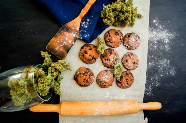 Cookies with cannabis and buds of marijuana on the table. top viewConcept of cooking with cannabis herb. Treatment of medical marijuana for use in food top view, On a black background — Stock Photo, Image