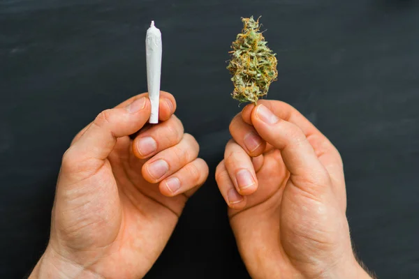 Hand of man rolled Joint buds of marijuana, unrolled weed on a white background top view close comfort — Stock Photo, Image