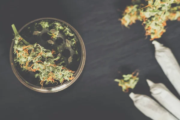 Mühle zum Zerkleinern von Cannabis und einer Blume Marihuana auf mattierter Vintage-Farbe — Stockfoto