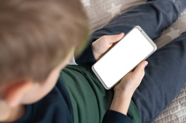 Elinde beyaz perde olan akıllı bir telefon, çocuk. Akıllı telefon, elinde bir çocuğun maketi var. Üst Manzarayı kapat. Model için telefon et..