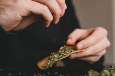 Çakmakla marihuana dükkanını kapat. Esrar saran bir adam. Esrar saran bir adam..