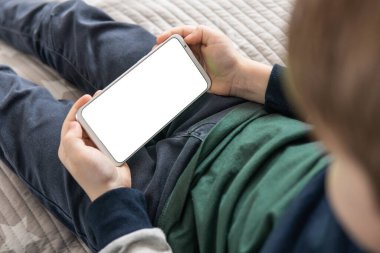 Model için telefon et, çocuğu tutuyor. Elinde beyaz perde olan akıllı bir telefon, çocuk. Akıllı telefon, elinde bir çocuğun maketi var. Üst görünüm kapat