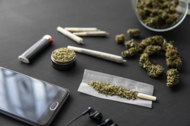 Elinde taze kenevir, esrarlı esrar, siyah masada marihuana tomurcukları, kapat.,