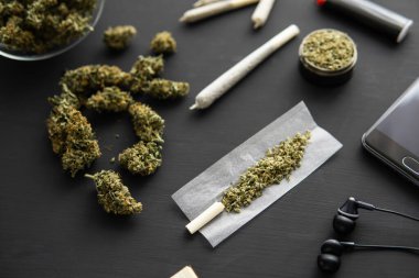 Marihuana tomurcukları siyah masada, öğütücü elinde taze kenevirle, esrar ile esrar, yakın çekim,