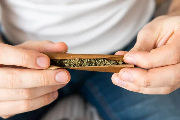 마리화나 Grinder Cannabis 개념을 배경에 대마초를 날리는 사람의 마리화나 준비하고 — 스톡 사진