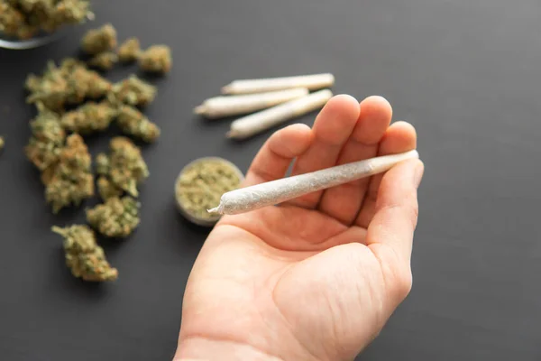 Articulación Mano Con Hierba Brotes Cannabis Mesa Negra Vista Superior — Foto de Stock