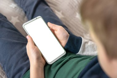 Akıllı telefon, elinde bir çocuğun maketi var. Elinde beyaz perde olan akıllı bir telefon, çocuk. Üst Manzarayı kapat. Model için telefon et..