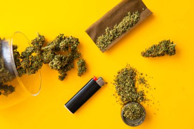 Blunt ve Lighters. Taze marihuana. Kenevir tomurcukları için CBD ve THC. Üst Manzara. Kopyalama alanı için sarı arka planda esrar tomurcukları. Kenevir yasallaştırması.