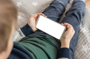 Akıllı telefon, elinde bir çocuğun maketi var. Elinde beyaz perde olan akıllı bir telefon, çocuk. Model için telefon et, çocuğu tutuyor. en üstteki görünüm