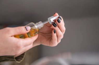 Petrol keneviri CBD pipette kadın eli, yakın plan, beyaz arka plan marihuana özü, tıbbi kenevir konsepti, ot ürünü,