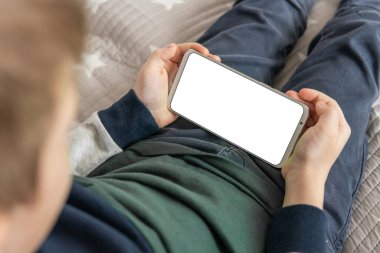 Akıllı telefon, elinde bir çocuğun maketi var. Model için telefon et, çocuğu tutuyor. Elinde beyaz perde olan akıllı bir telefon, çocuk. en üstteki görünüm