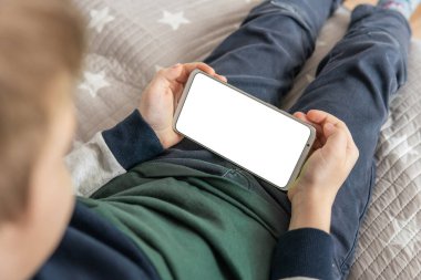 Model için telefon et, çocuğu tutuyor. Akıllı telefon, elinde bir çocuğun maketi var. Elinde beyaz perde olan akıllı bir telefon, çocuk. Üst görünüm kapat