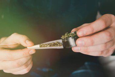 Esrarkeşin çakmakla esrar içtiği yeri kapatın. Uyuşturucu narkotik konsepti. Kapatın. Uyuşturucu kullanımı. Marihuana hazırlayan ve yuvarlayan adam. Esrar saran bir adam.