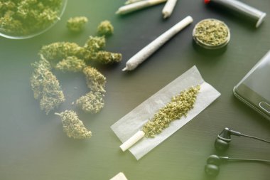 Siyah masada marihuana tomurcukları, yakın çekim, taze kenevirle öğütücü, esrarlı esrar, ışık renk akıntısı