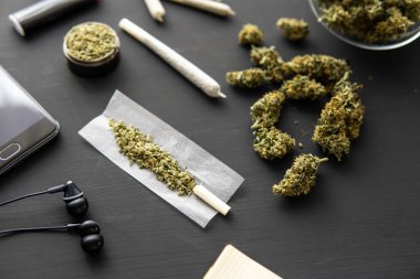 Siyah masada marihuana tomurcukları, esrarlı esrar, yakın çekim, taze kenevirle el değirmeni,