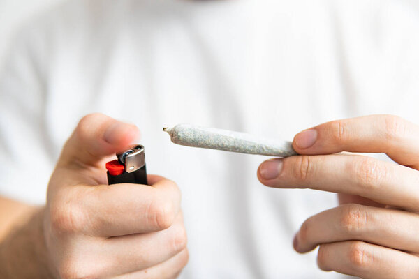 Smoking marijuana at home. Man smoking weed indoor. Close up . Recreational use of cannabis.