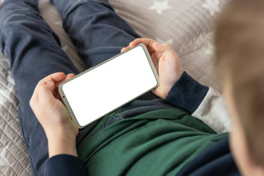 Akıllı telefon, elinde bir çocuğun maketi var. Model için telefon et, çocuğu tutuyor. Elinde beyaz perde olan akıllı bir telefon, çocuk. en üstteki görünüm