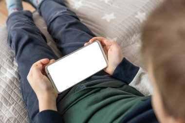 Model için telefon et, çocuğu tutuyor. Akıllı telefon, elinde bir çocuğun maketi var. Elinde beyaz perde olan akıllı bir telefon, çocuk. en üstteki görünüm