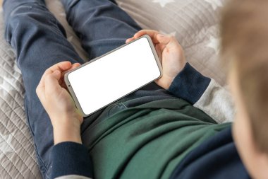 Akıllı telefon, elinde bir çocuğun maketi var. Model için telefon et, çocuğu tutuyor. Elinde beyaz perde olan akıllı bir telefon, çocuk. en üstteki görünüm