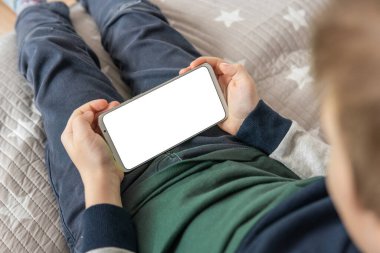 Model için telefon et, çocuğu tutuyor. Akıllı telefon, elinde bir çocuğun maketi var. Elinde beyaz perde olan akıllı bir telefon, çocuk. en üstteki görünüm