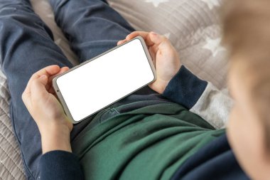 Elinde beyaz perde olan akıllı bir telefon, çocuk. Akıllı telefon, elinde bir çocuğun maketi var. Model için telefon et, çocuğu tutuyor. en üstteki görünüm