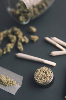 Yakın plan, elinde taze marihuana, esrarlı esrar, siyah masada esrar tomurcukları, dikey çekim