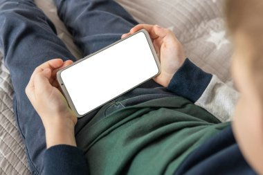 Akıllı telefon, elinde bir çocuğun maketi var. Elinde beyaz perde olan akıllı bir telefon, çocuk. Model için telefon et, çocuğu tutuyor. Üst görünüm kapat