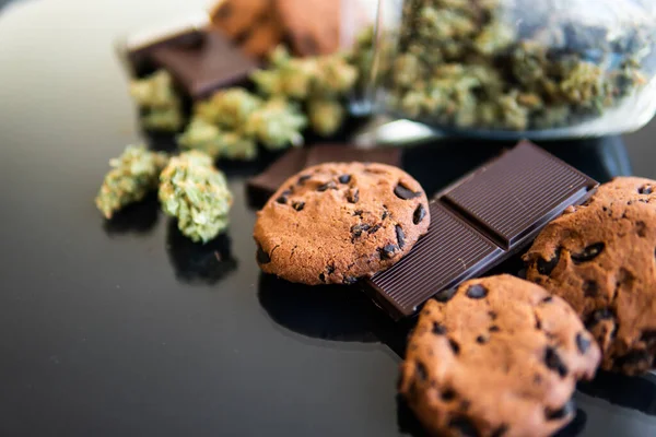 桌上放着大麻和大麻芽的巧克力和饼干 含大麻药草的饼干和巧克力的概念用于食品的医用大麻治疗 黑色背景 — 图库照片
