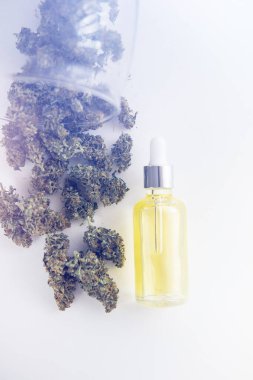 Tıbbi marihuana konsepti, yakın plan, CBD kenevir yağı, doğal bitki, pipetteki kenevir yağı, ışık renk tonlarını dikey çekimde sızdırıyor