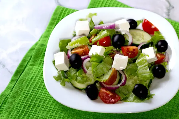 Frischer griechischer Salat auf weißem Tisch — Stockfoto