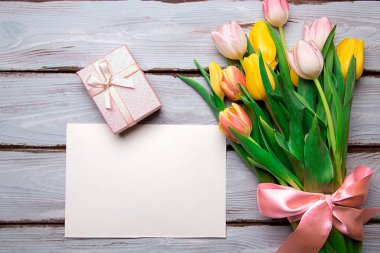 Tahta bir masanın üzerinde bir buket lale.