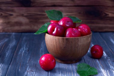 Ahşap masa üzerinde kırmızı Erik