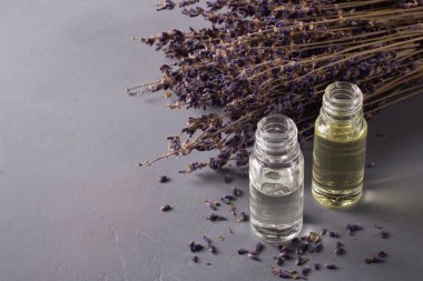 Mavi çiçekli bir şişe lavanta yağı. Aromaterapi