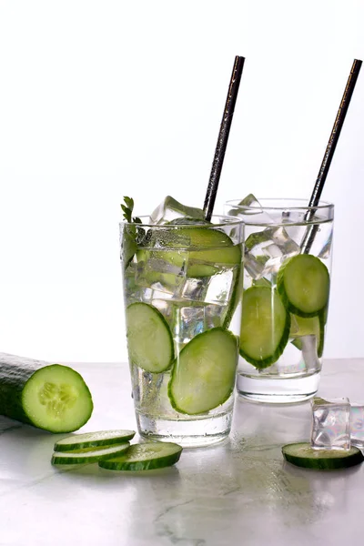 Glas komkommerwater met ijs op witte ondergrond. — Stockfoto