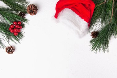 Noel arkaplanı köknar ve beyaz arka planda Noel Baba şapkası. Düz yatıyordu. Model.