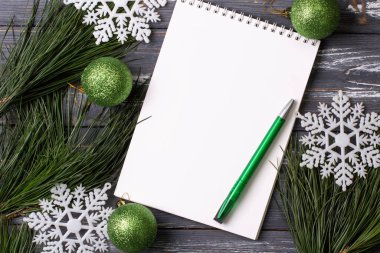 Noel arkaplanı boş defter, çam dalları ve tahta masada Noel oyuncakları. Uzayı kopyala Düz yatıyordu