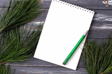 Noel arkaplanı boş defter, çam dalları ve tahta masada Noel oyuncakları. Uzayı kopyala Düz yatıyordu