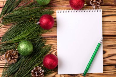 Noel arkaplanı boş defter, çam dalları ve tahta masada Noel oyuncakları. Uzayı kopyala Düz yatıyordu