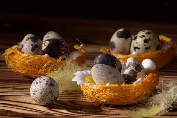 Velikonoční vajíčka v koši s peřím. Na černém pozadí. Ranní světlo. — Stock fotografie