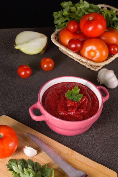 Tomato soup with parsley, onion and garlic on gray background. Comfortable food. Rustic style — Stock Photo, Image