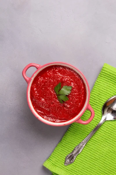 Tomato soup with parsley, onion and garlic on gray background. Comfortable food. Rustic style. Copy space. — Stock Photo, Image