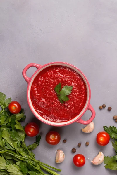 Zupa pomidorowa z pietruszką, cebulą i czosnkiem na szarym tle. Wygodne jedzenie. Styl rustykalny. Przestrzeń kopiowania. — Zdjęcie stockowe