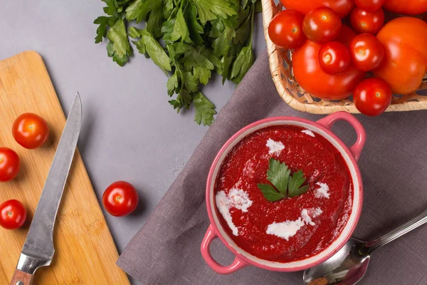 Tomato soup with parsley, onion and garlic on gray background. Comfortable food. Rustic style. Copy space. — Stock Photo, Image