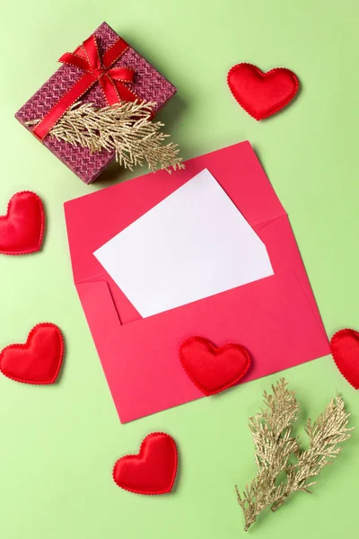 Золотая ветвь с открыткой, подарочной коробкой и сердечками на зеленом фоне. Принято. Вид сверху . — стоковое фото