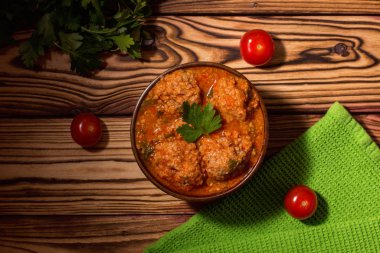Domates soslu köfte ve ahşap arka planda maydanoz. Keto diyet yemeği. Ketojenik. 