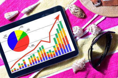Finansal takvimi olan bir tablet, plaj havlusu, güneş gözlüğü ve deniz kabuğu. İş çizelgesi. Tatilde serbest çalışan.