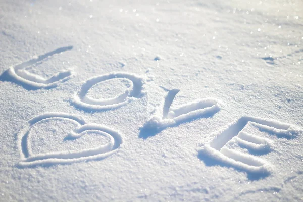 Kar ve kalp üzerinde yazılı kelime aşk